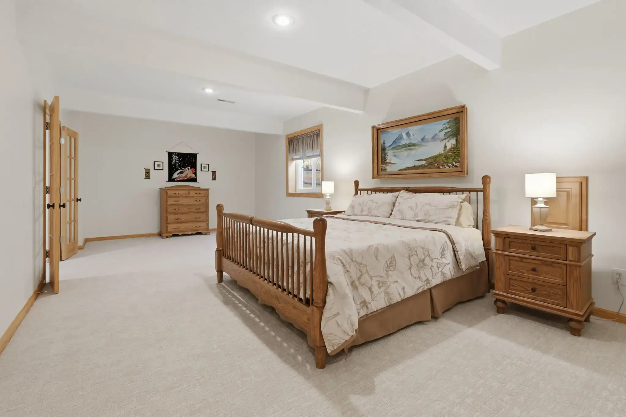 Lower-level bedroom with daylight window and wood furniture
