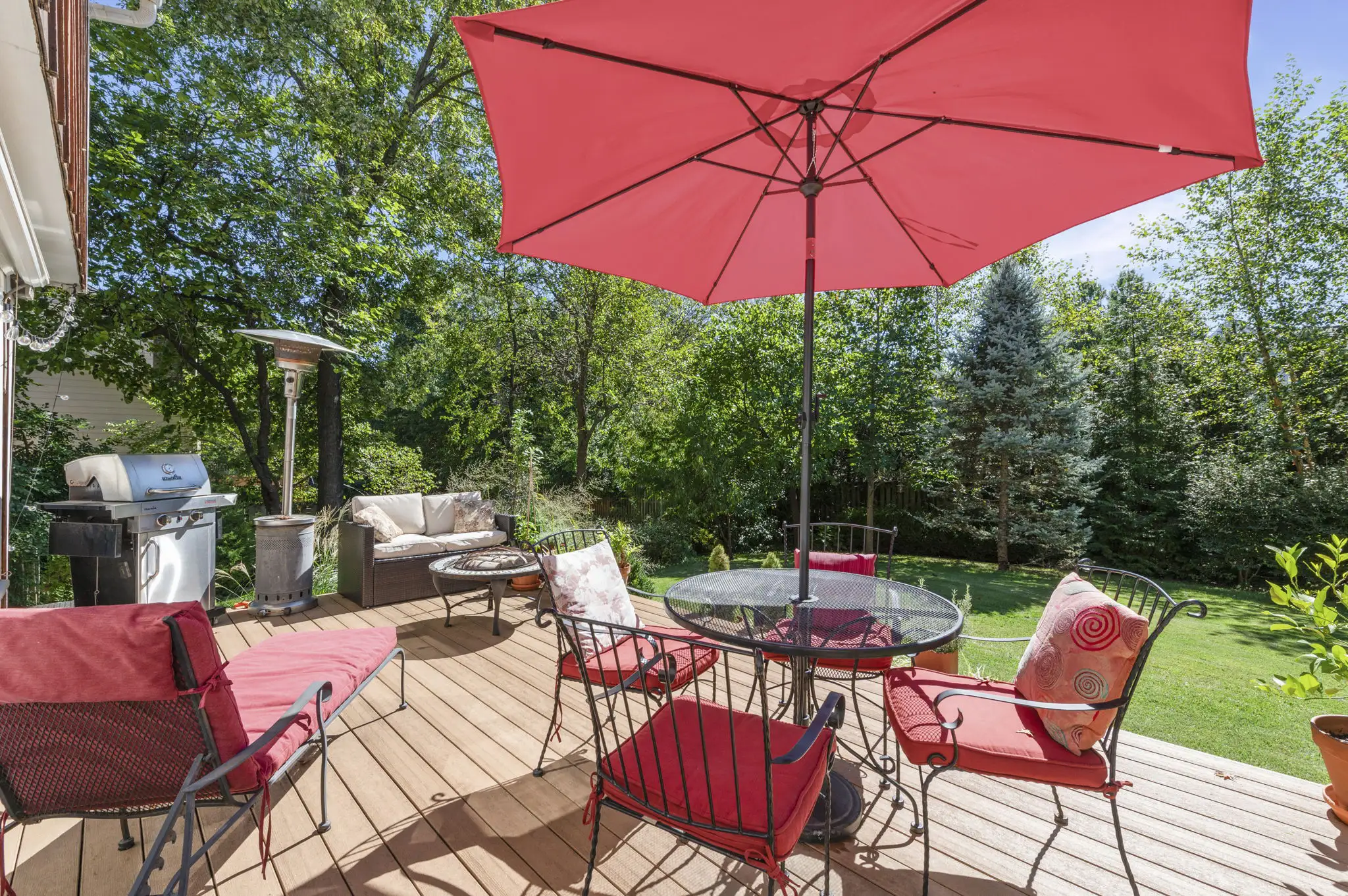 Composite deck with room for dining and lounging, framed by trees