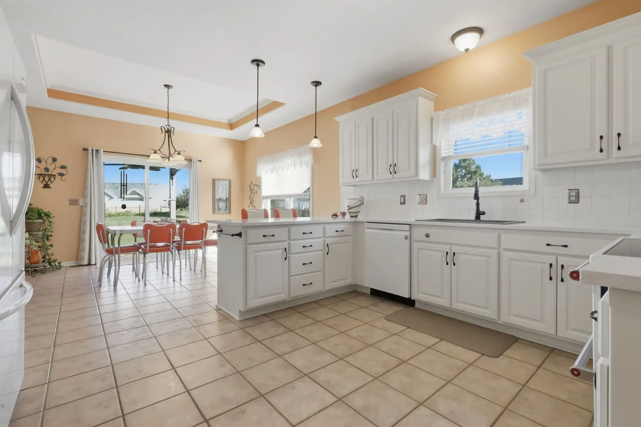 Spacious white kitchen with tile floors