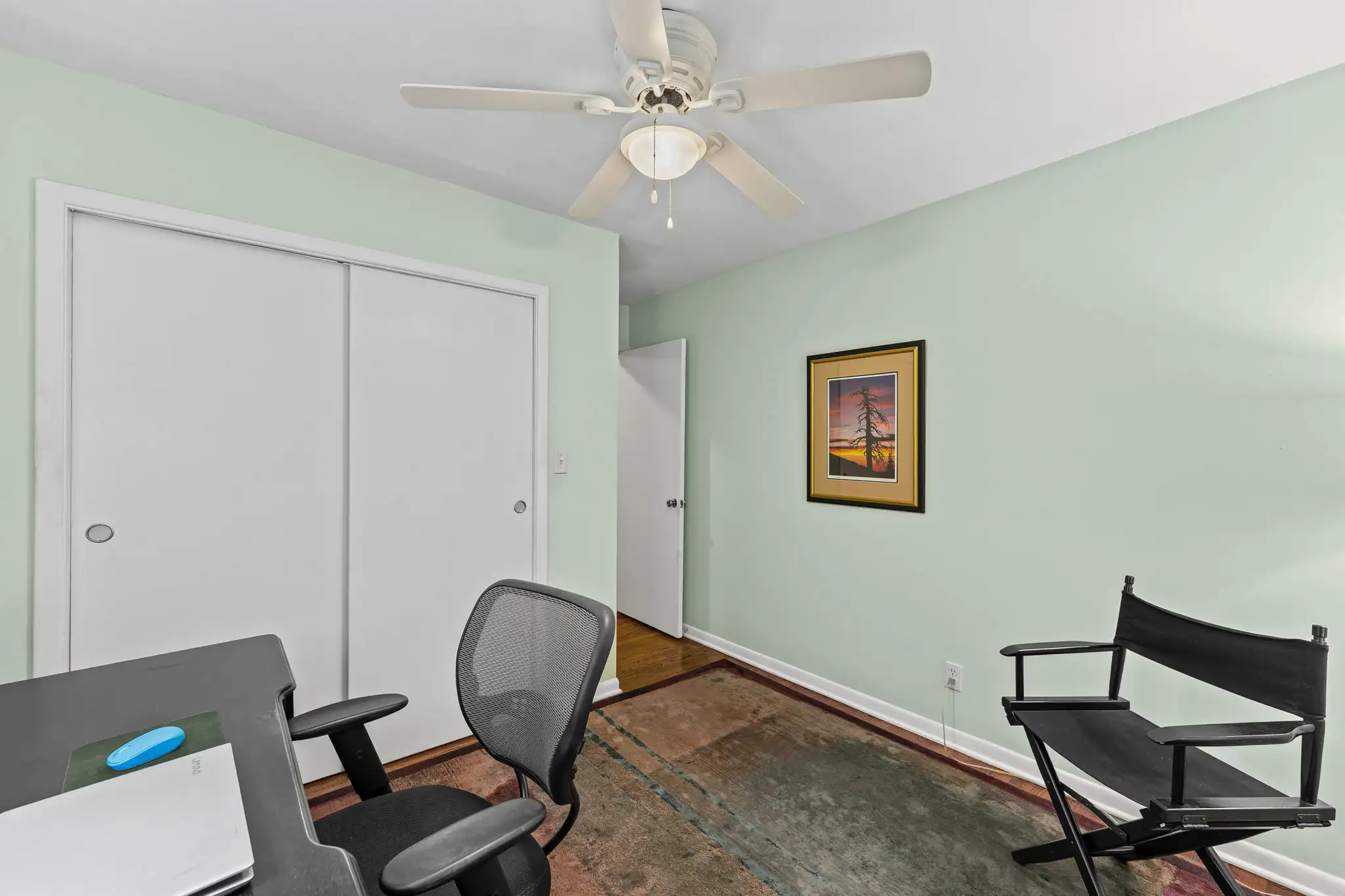 Secondary bedroom with sliding closet doors and a ceiling fan