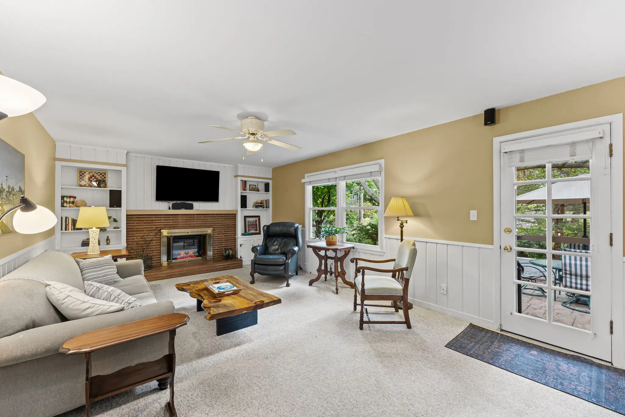 Family room with a brick fireplace and a door out to the patio