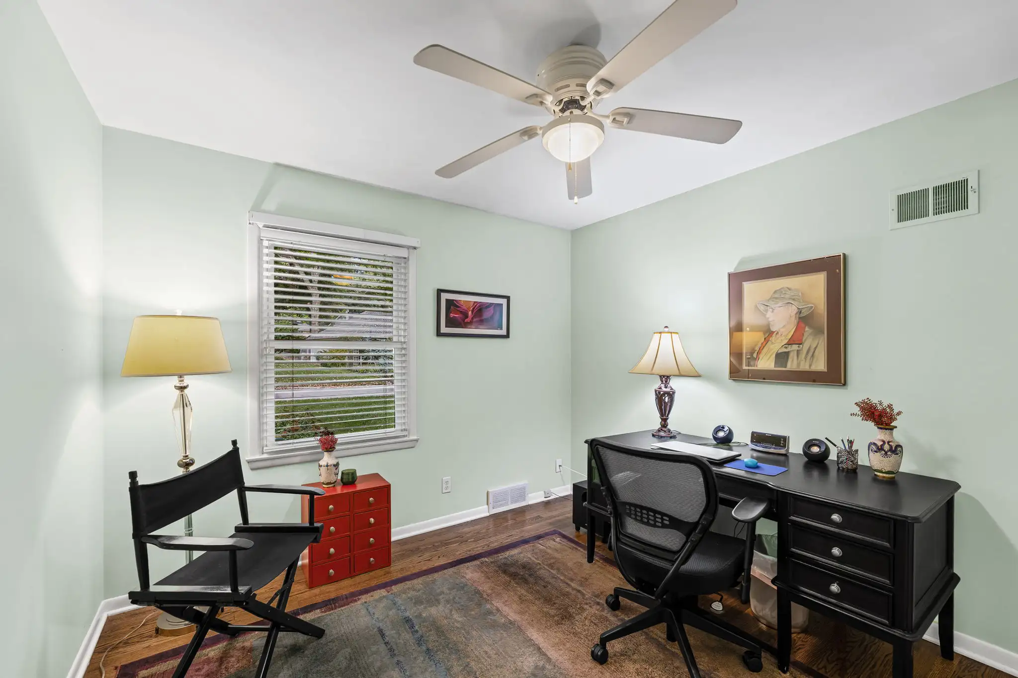 Secondary bedroom set up as a home office with hardwood floors