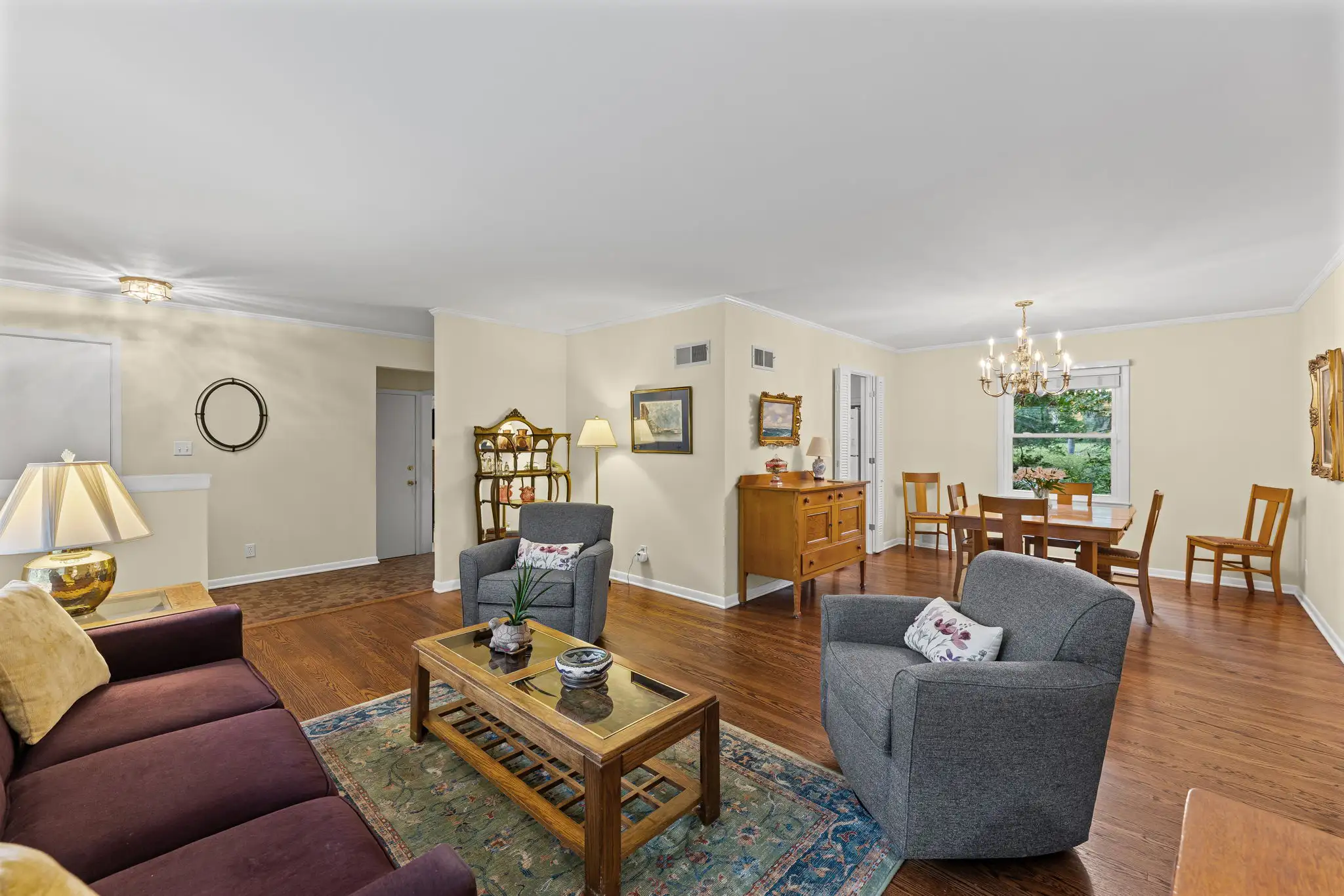 Living room opening to the formal dining room with a brass chandelier