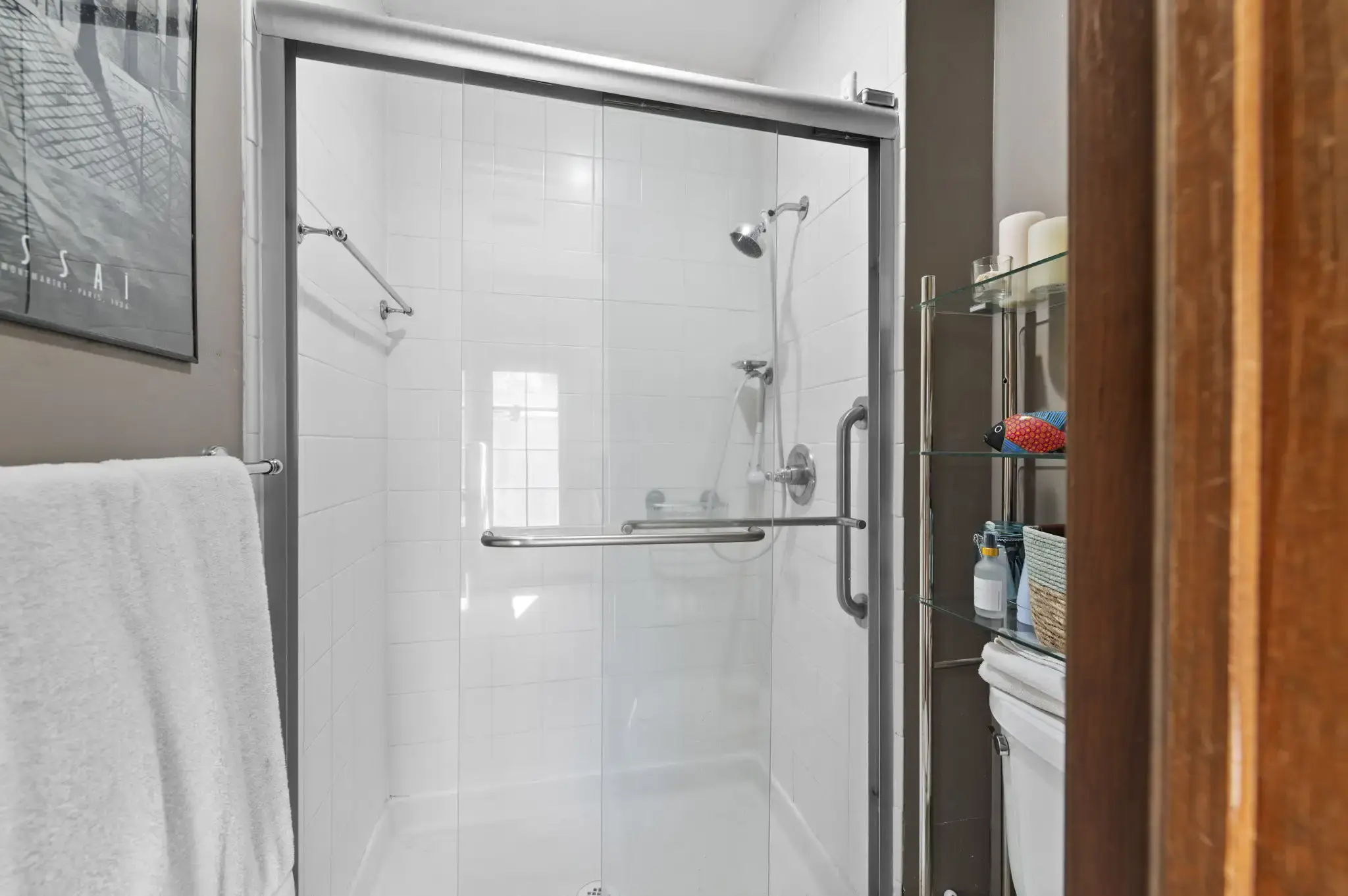 Primary bath walk-in shower with glass door and white tile