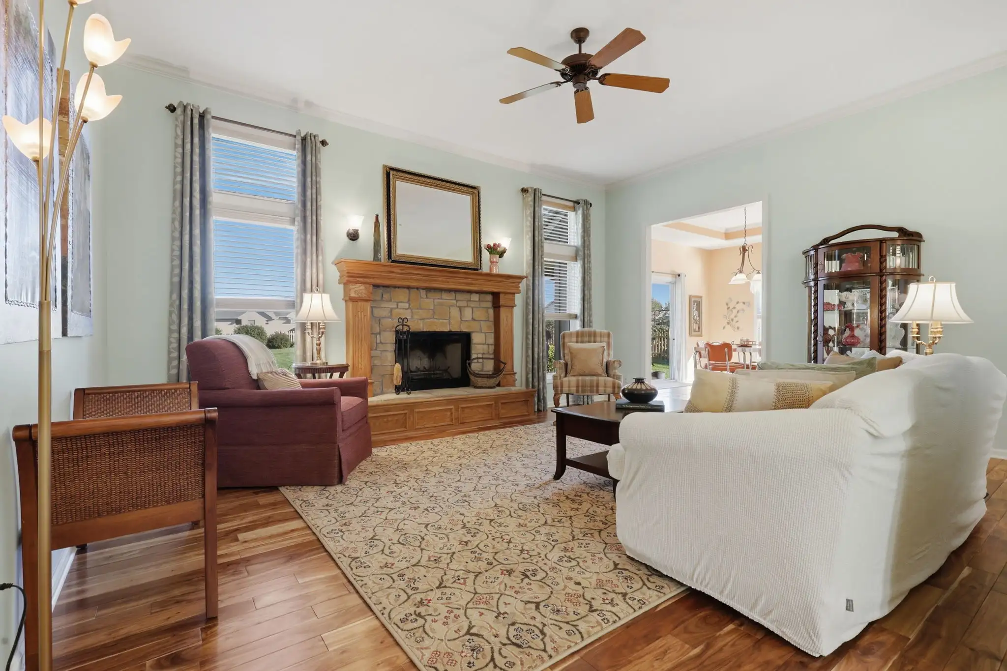 Living room with stone fireplace, wood mantel and Asian walnut floors