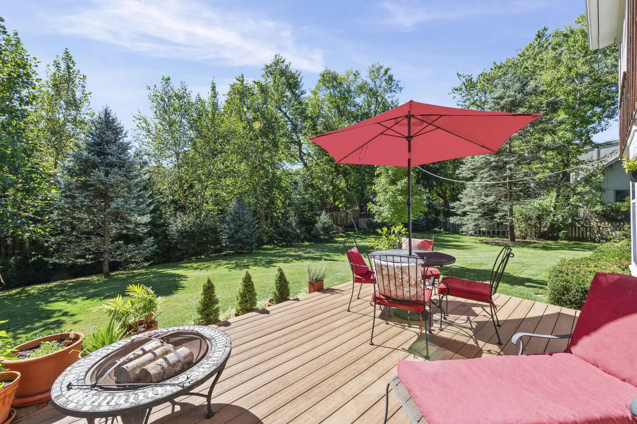 Composite deck stepping down to a deep, private backyard lawn