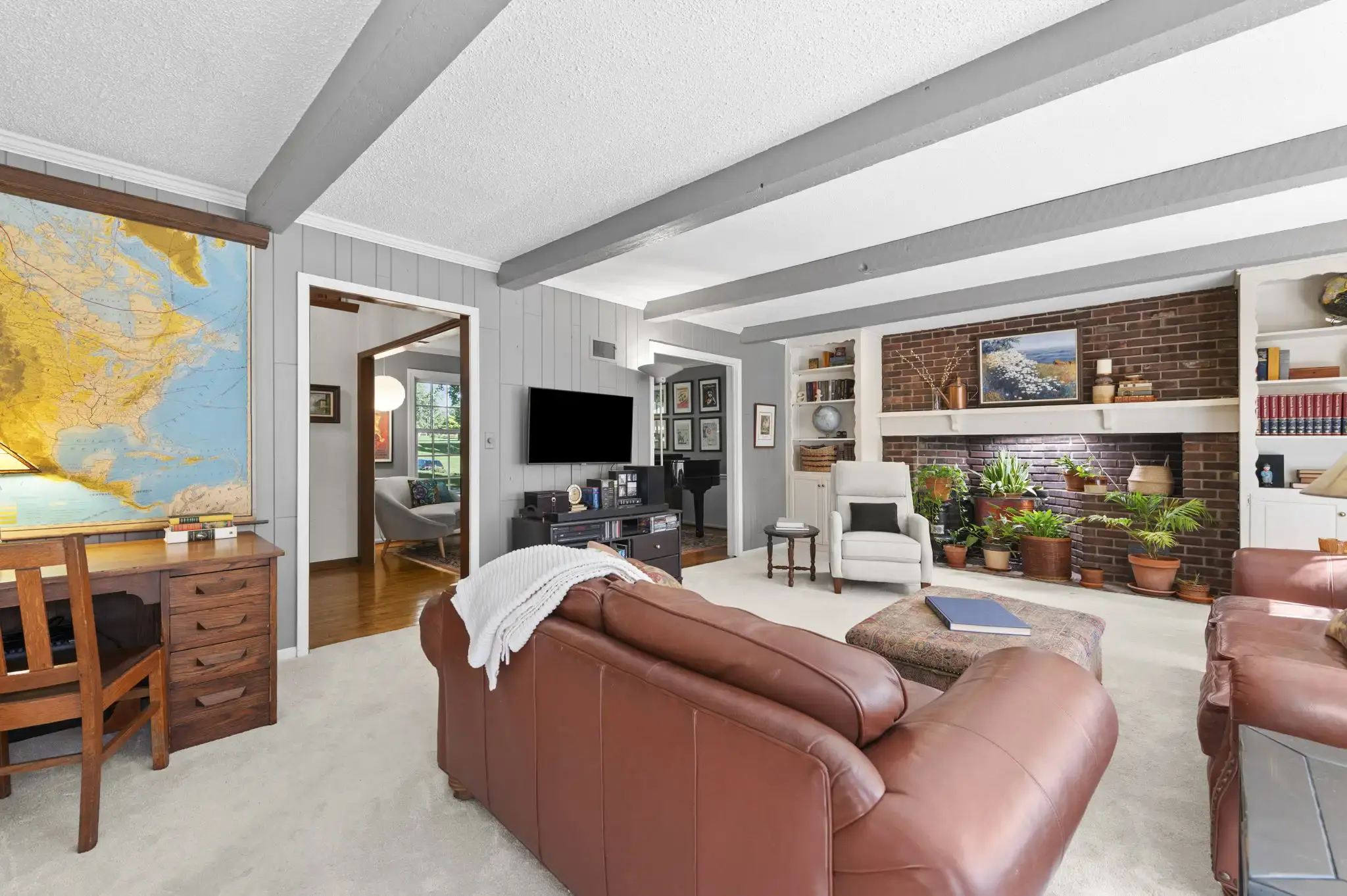 Family room with brick feature wall, mantel and built-in bookshelves