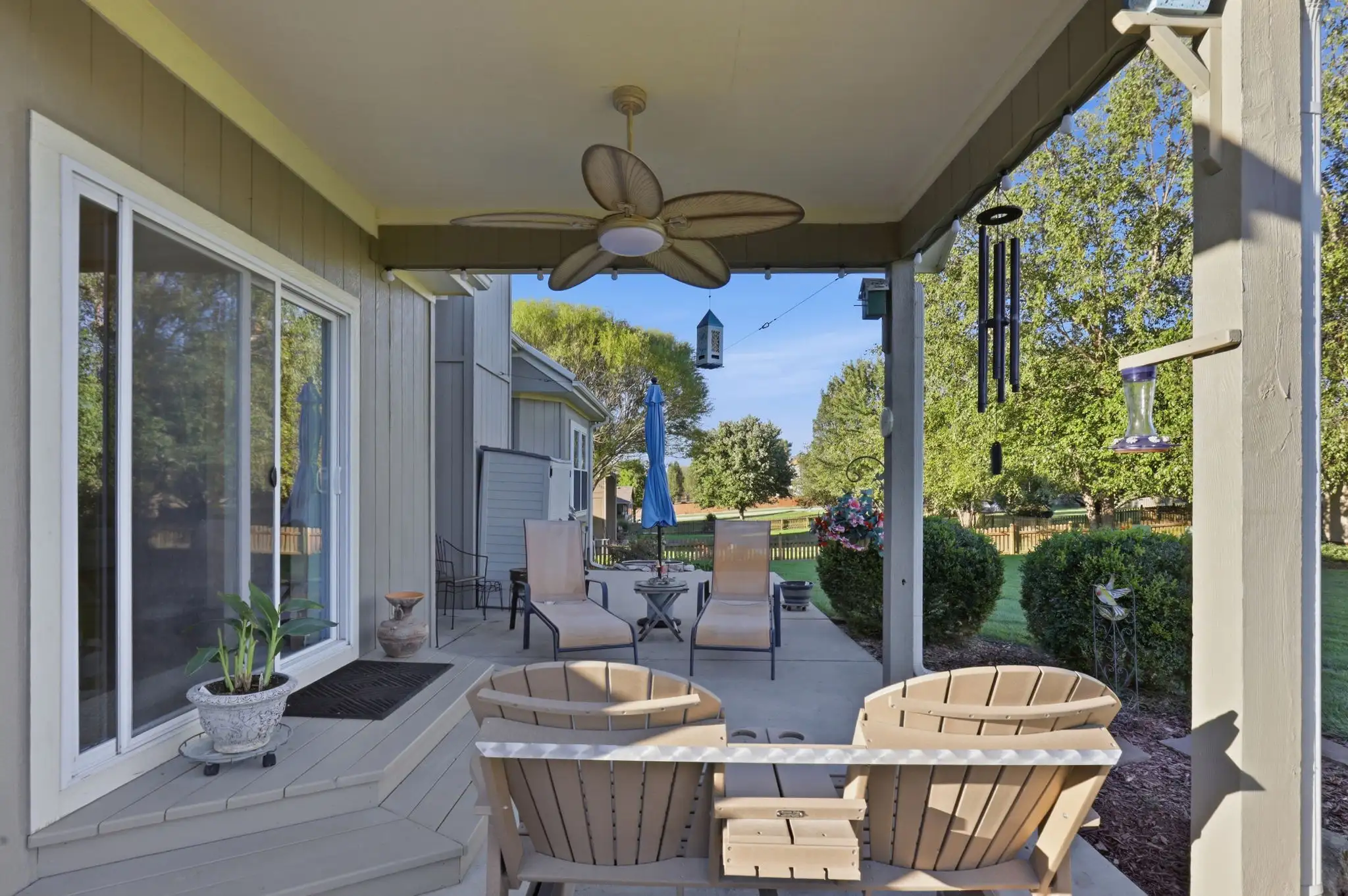 Covered patio with ceiling fan, sliding door and Adirondack chairs