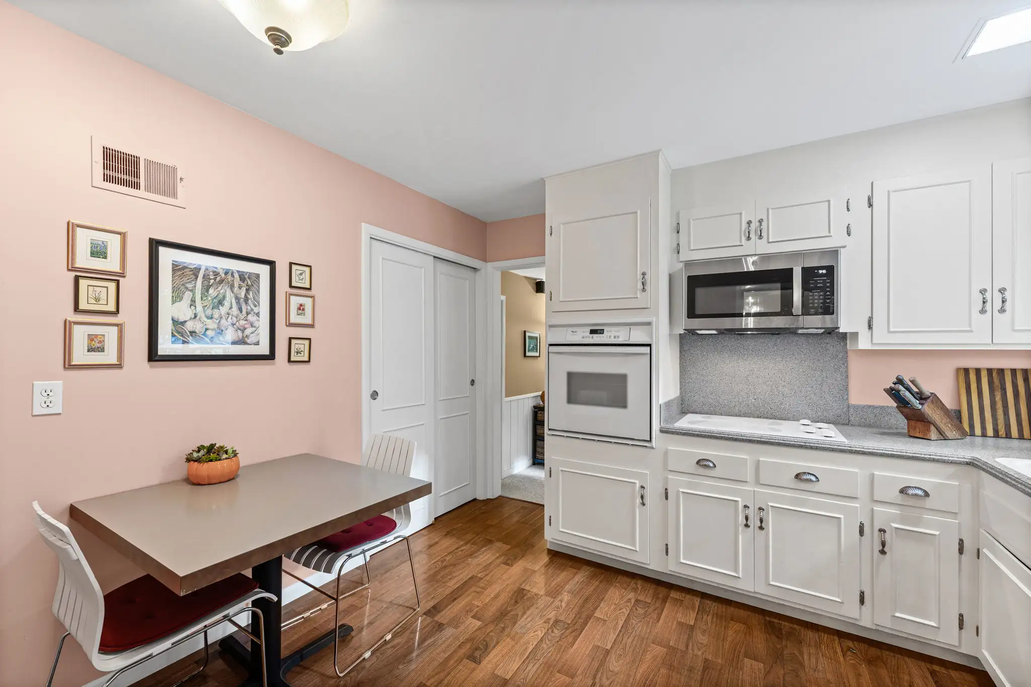 Kitchen with white cabinets, a built-in wall oven and a breakfast table