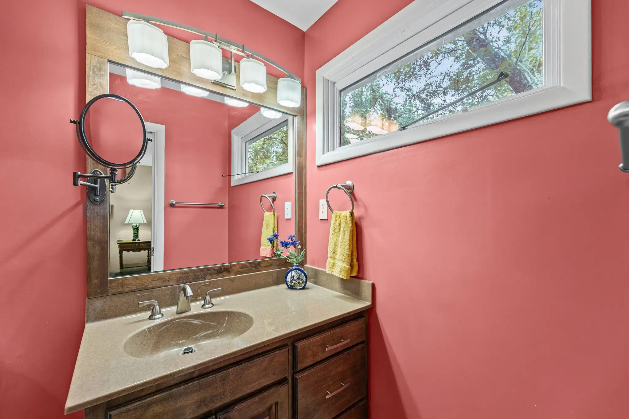 Primary bathroom vanity with a framed mirror and a transom window