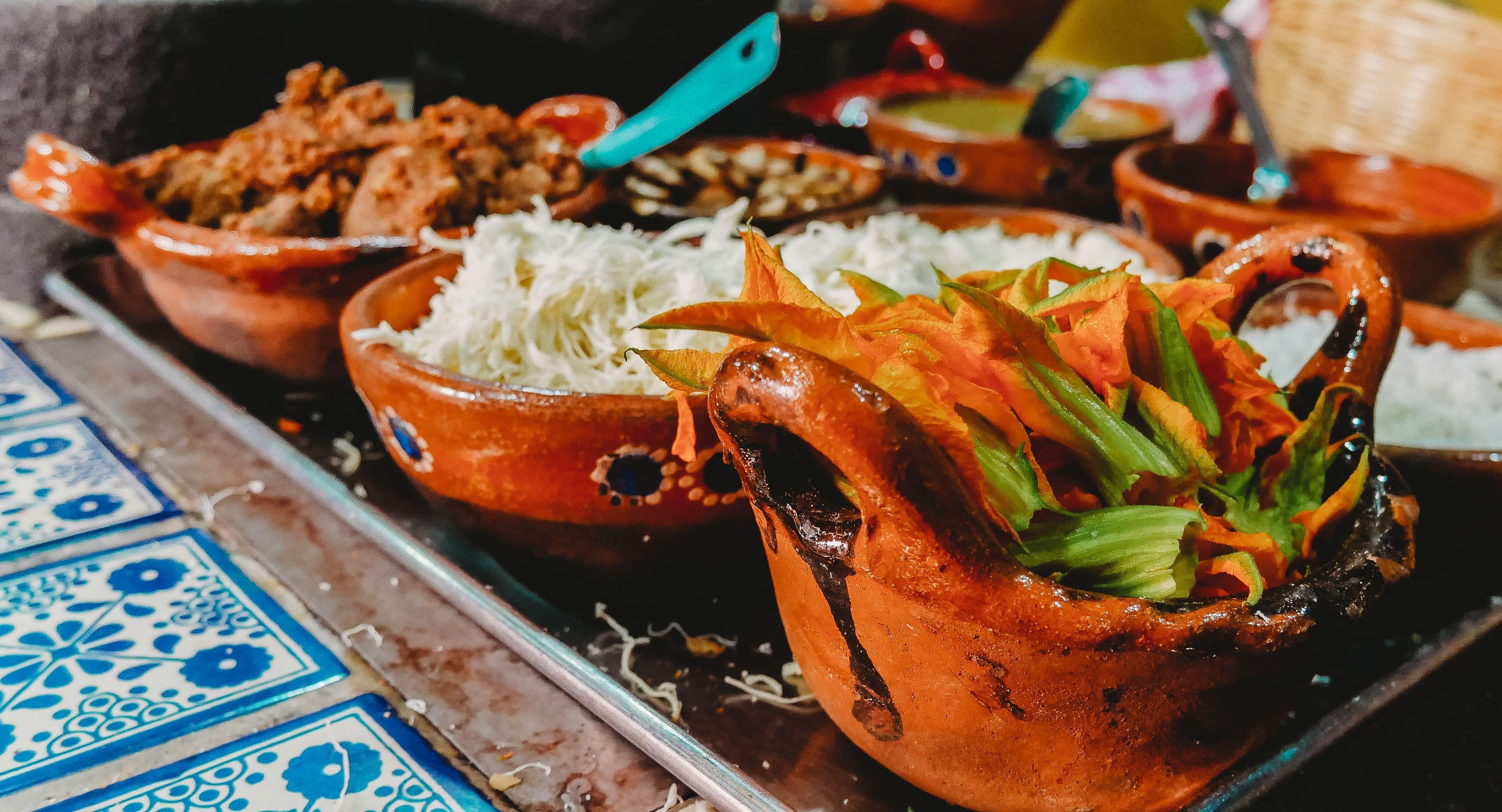 A platter of Mexican food in colorful clay dishes