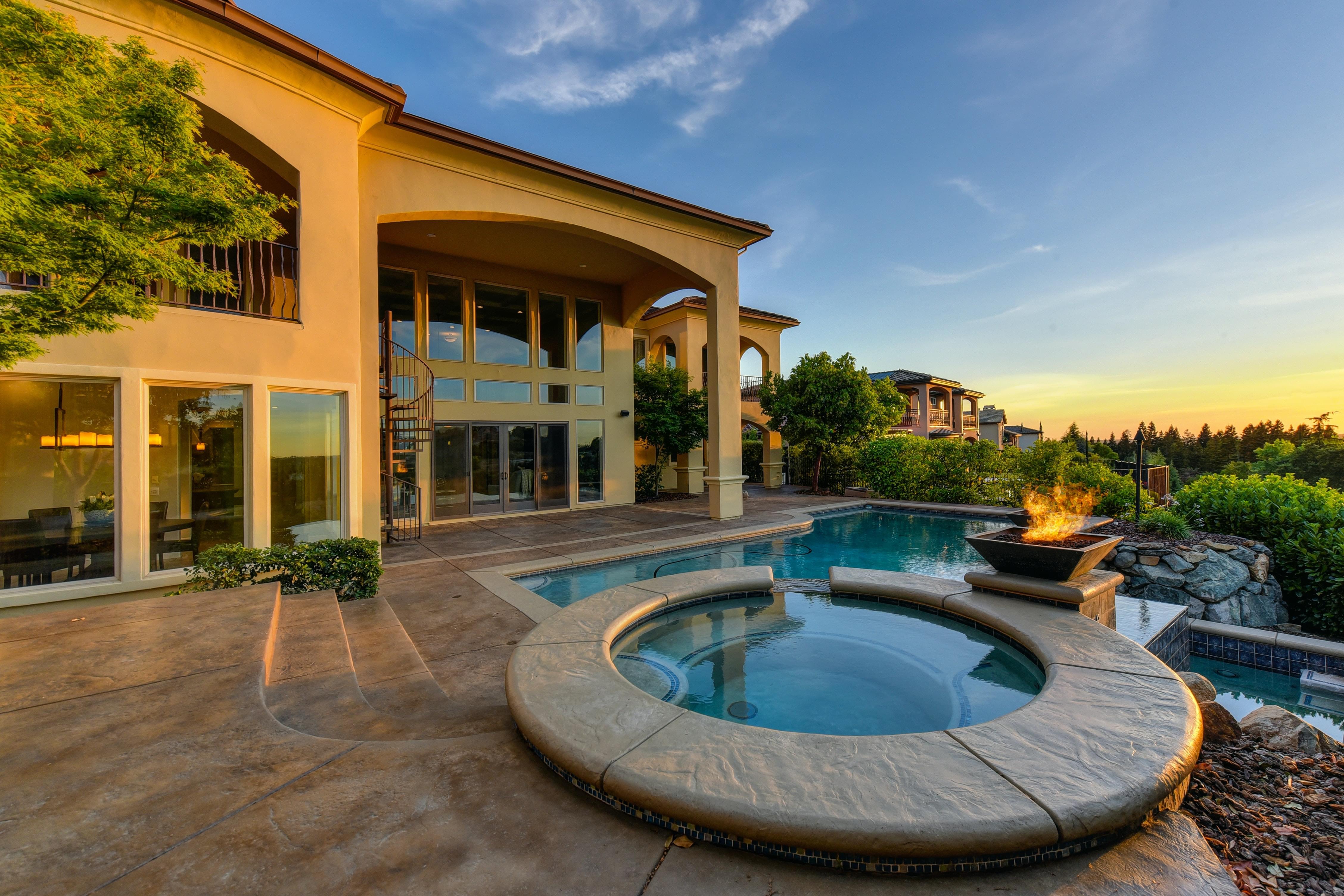 Luxury deserty home with pool and spa combination, fire pit, and floor-to-ceiling windows