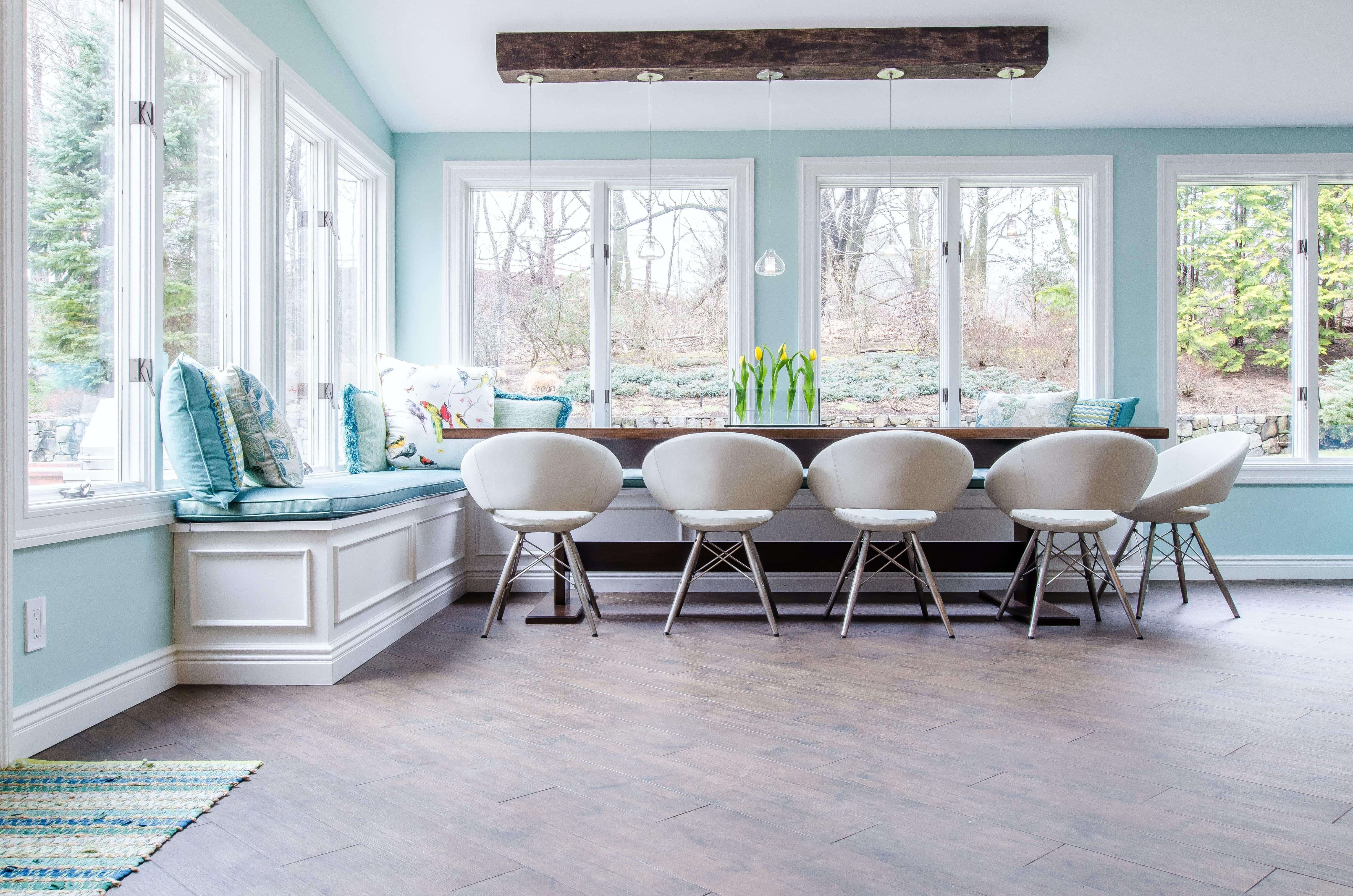 A light blue breakfast nook with built in bench and table with chairs