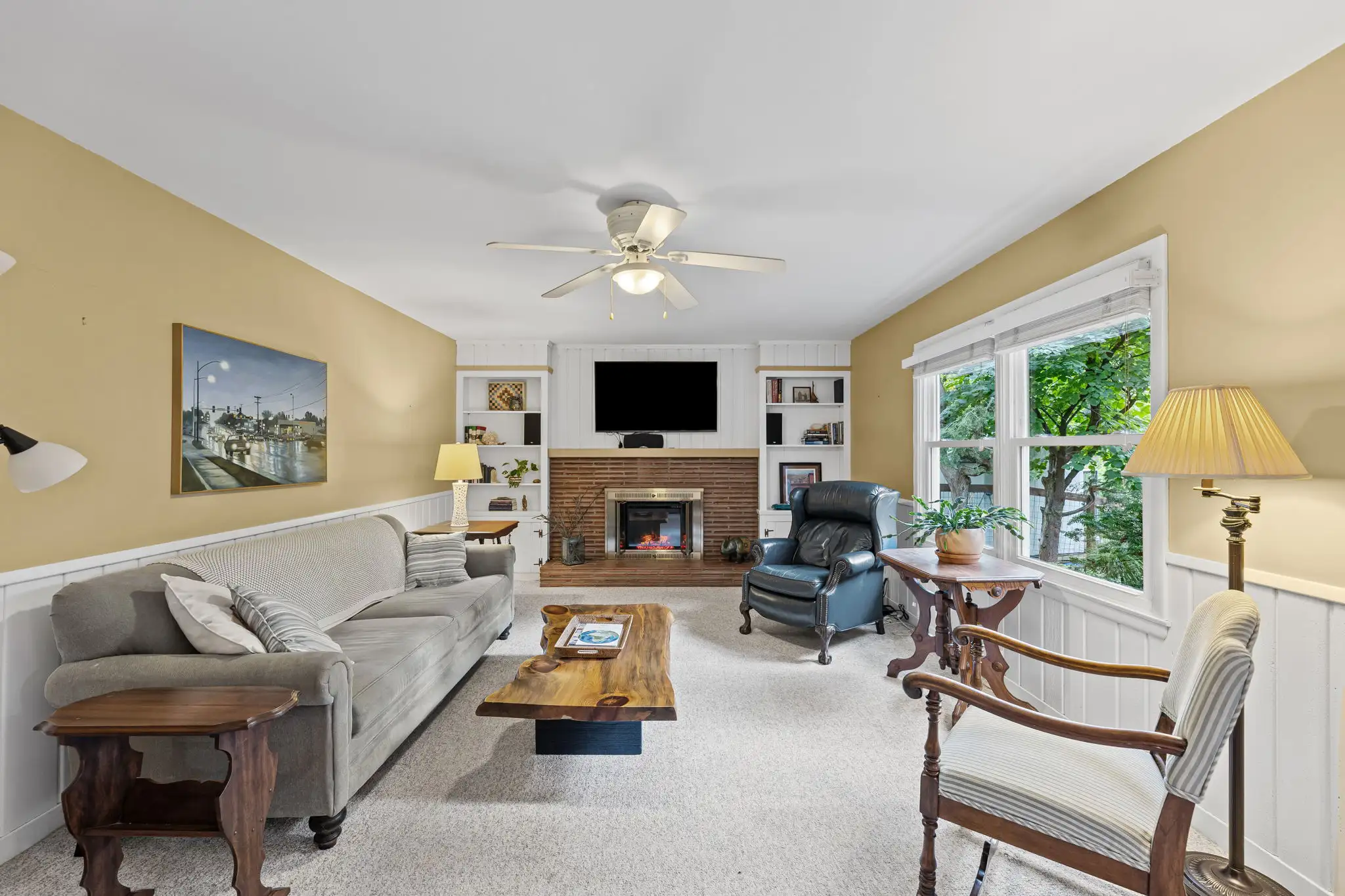 Family room with a brick fireplace flanked by built-in bookshelves