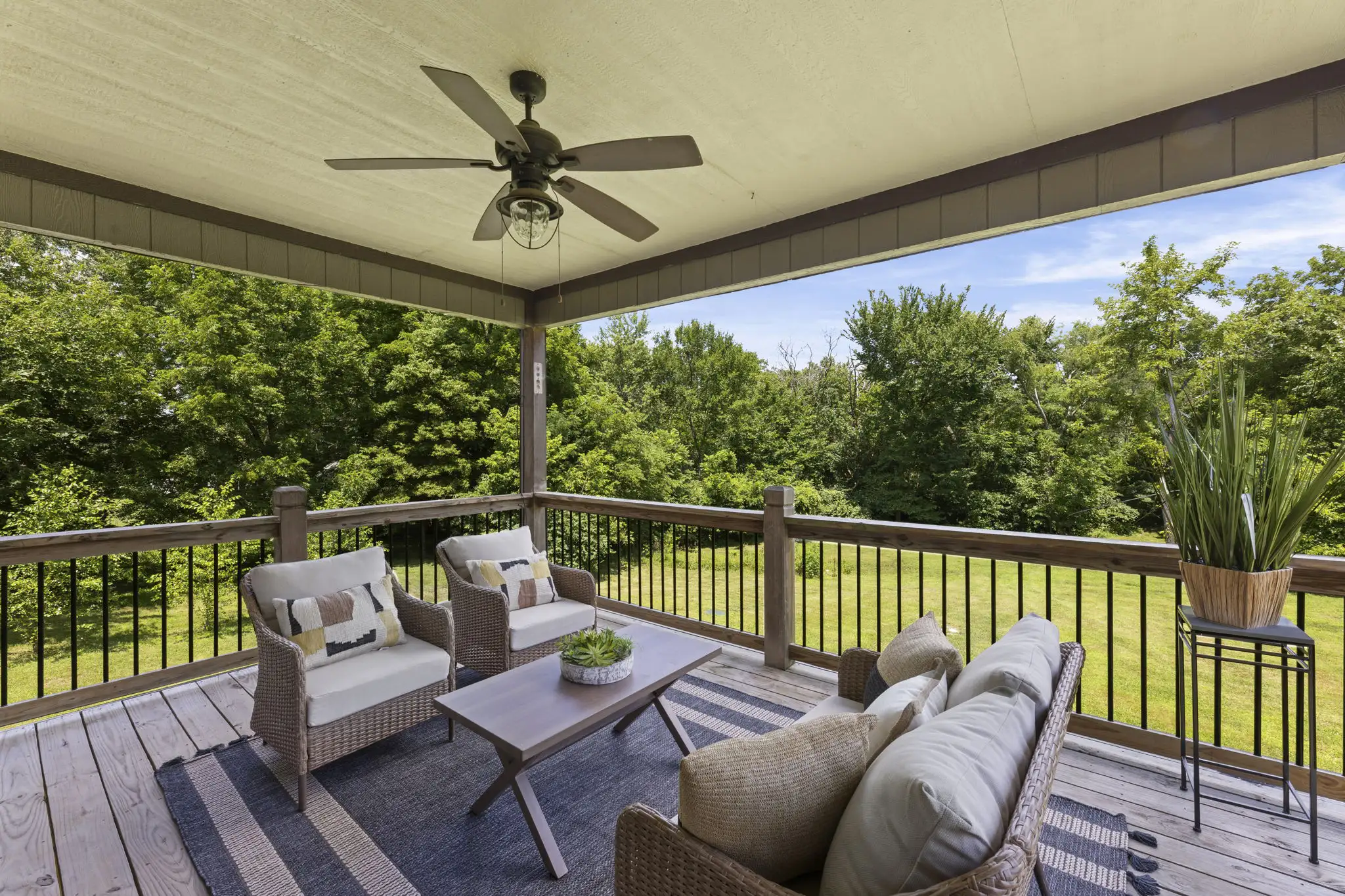 Covered upper deck overlooking a wooded 4.9-acre lot.