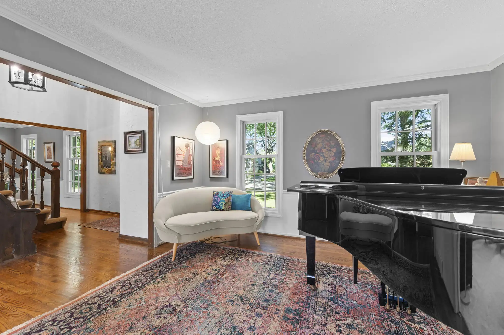 Formal living room with hardwood floors and a view to the foyer staircase