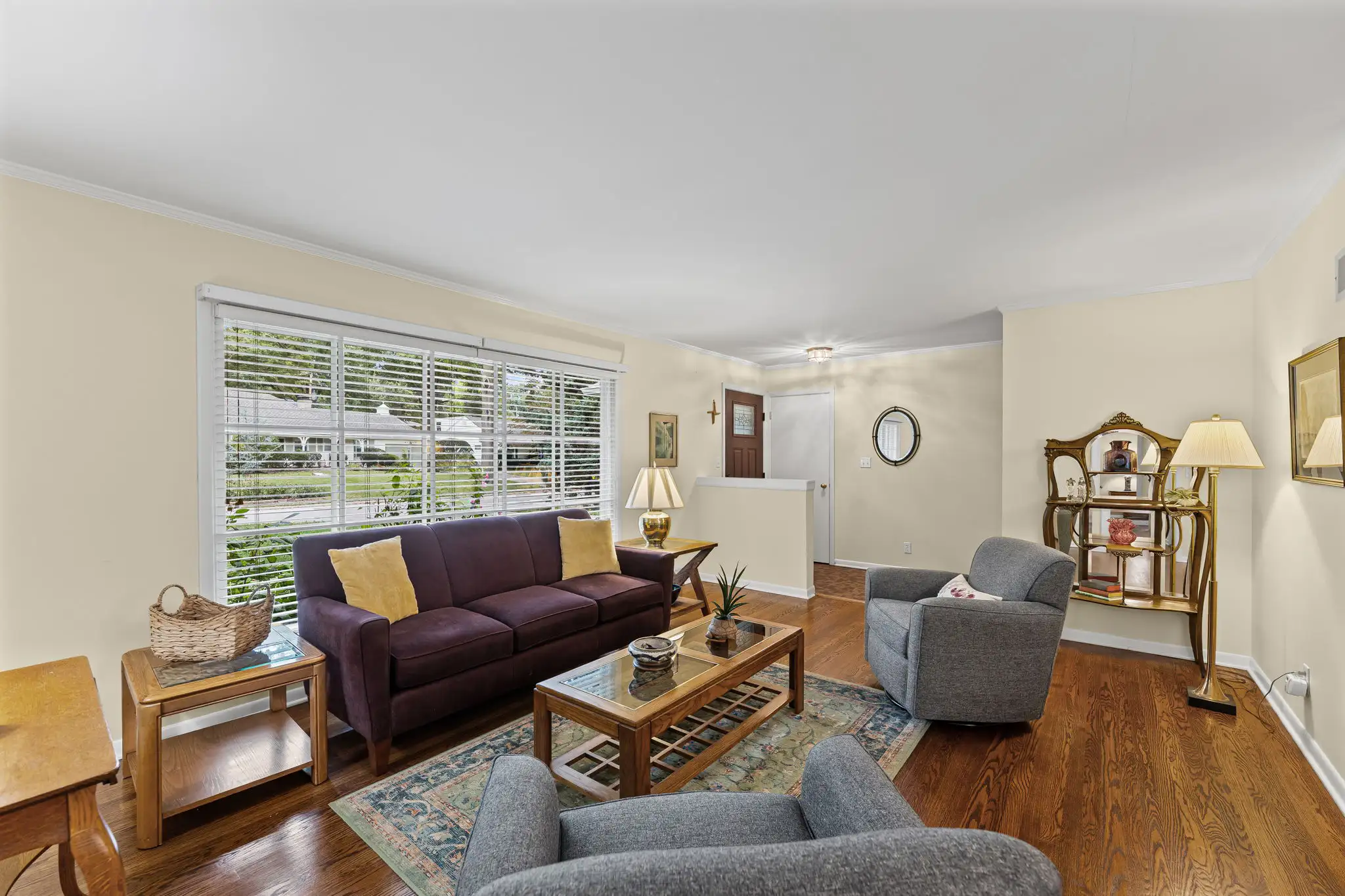 Living room with hardwood floors, a front window and a view toward the entry