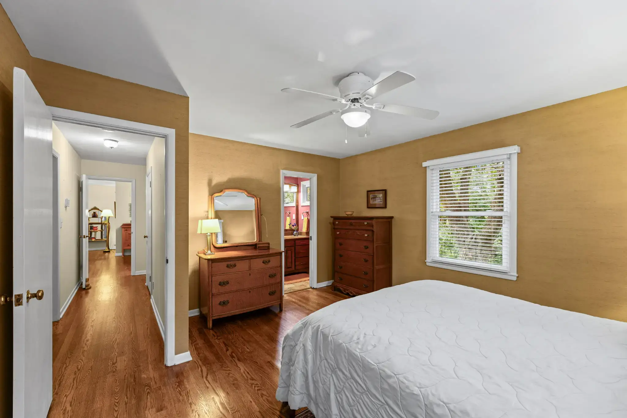 Primary bedroom with a doorway to the hall and its own bath