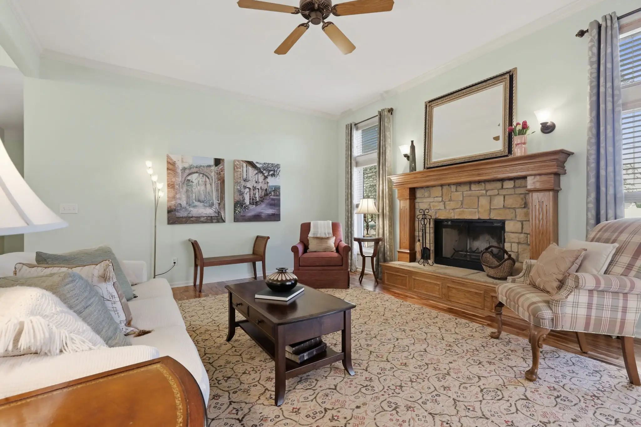 Living room with fireplace, ceiling fan and tall windows
