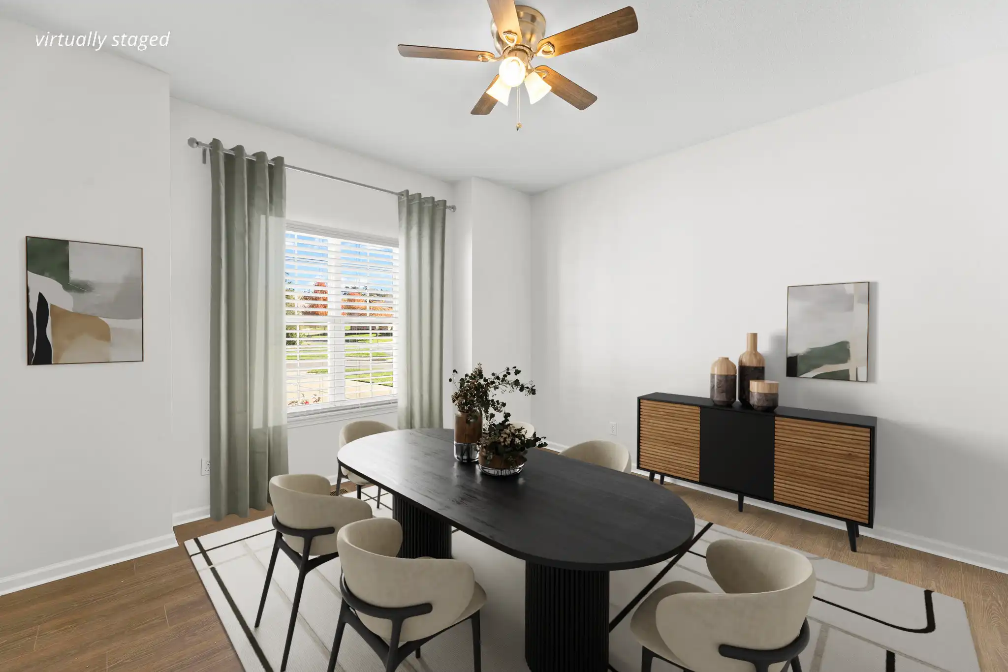 Virtually staged formal dining room at 21962 W 116th Terrace Olathe KS — large window, wood floors, black oval table, and soft green curtains.