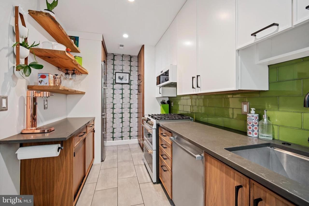 A stylish kitchen with natural wood accents, green glass subway tile backsplash, and modern finishes