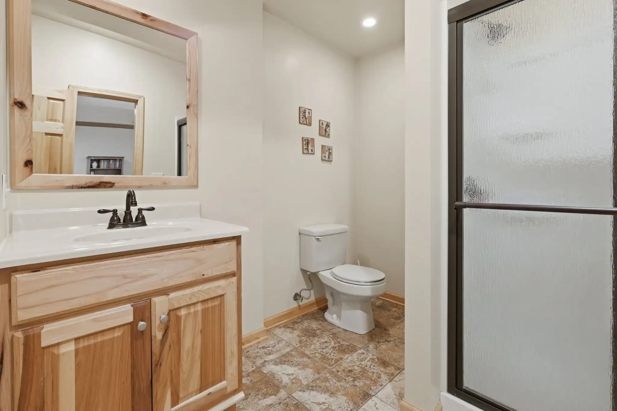 Lower-level full bath with walk-in shower and wood vanity