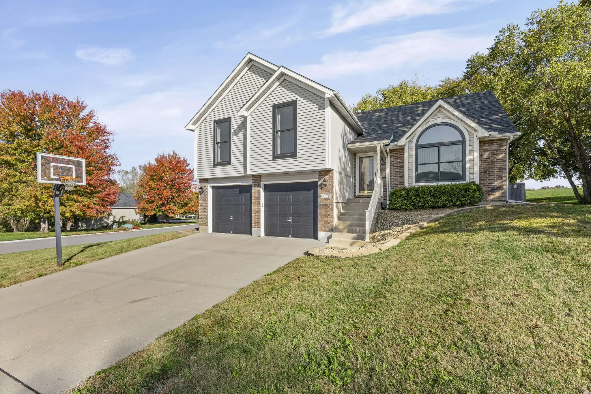 Front exterior view of 4075 N 107th Terrace in the Piper area of Kansas City, KS, featuring an updated home with an attached two-car garage.