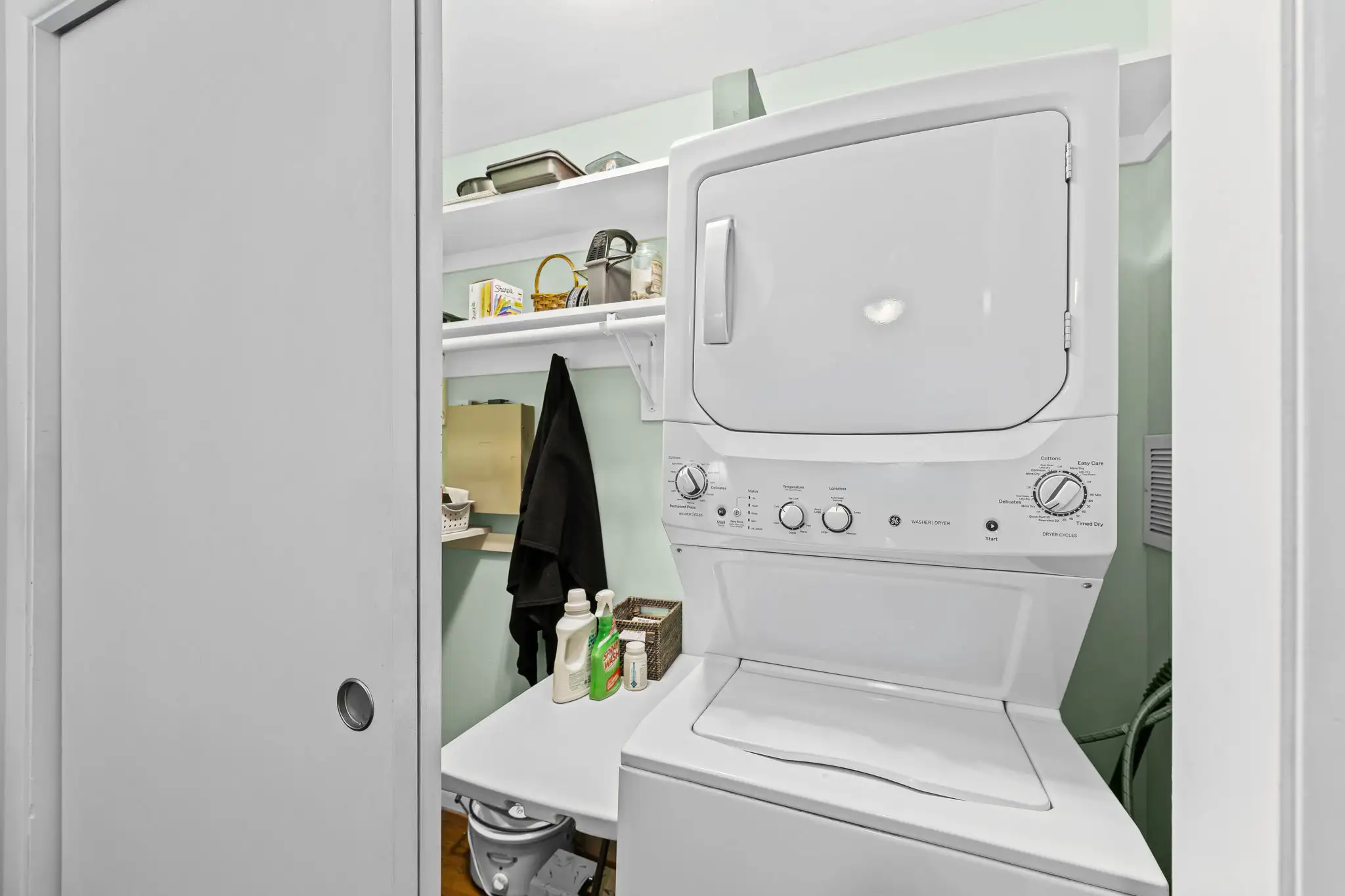 Bedroom closet converted to laundry with a stacked washer and dryer