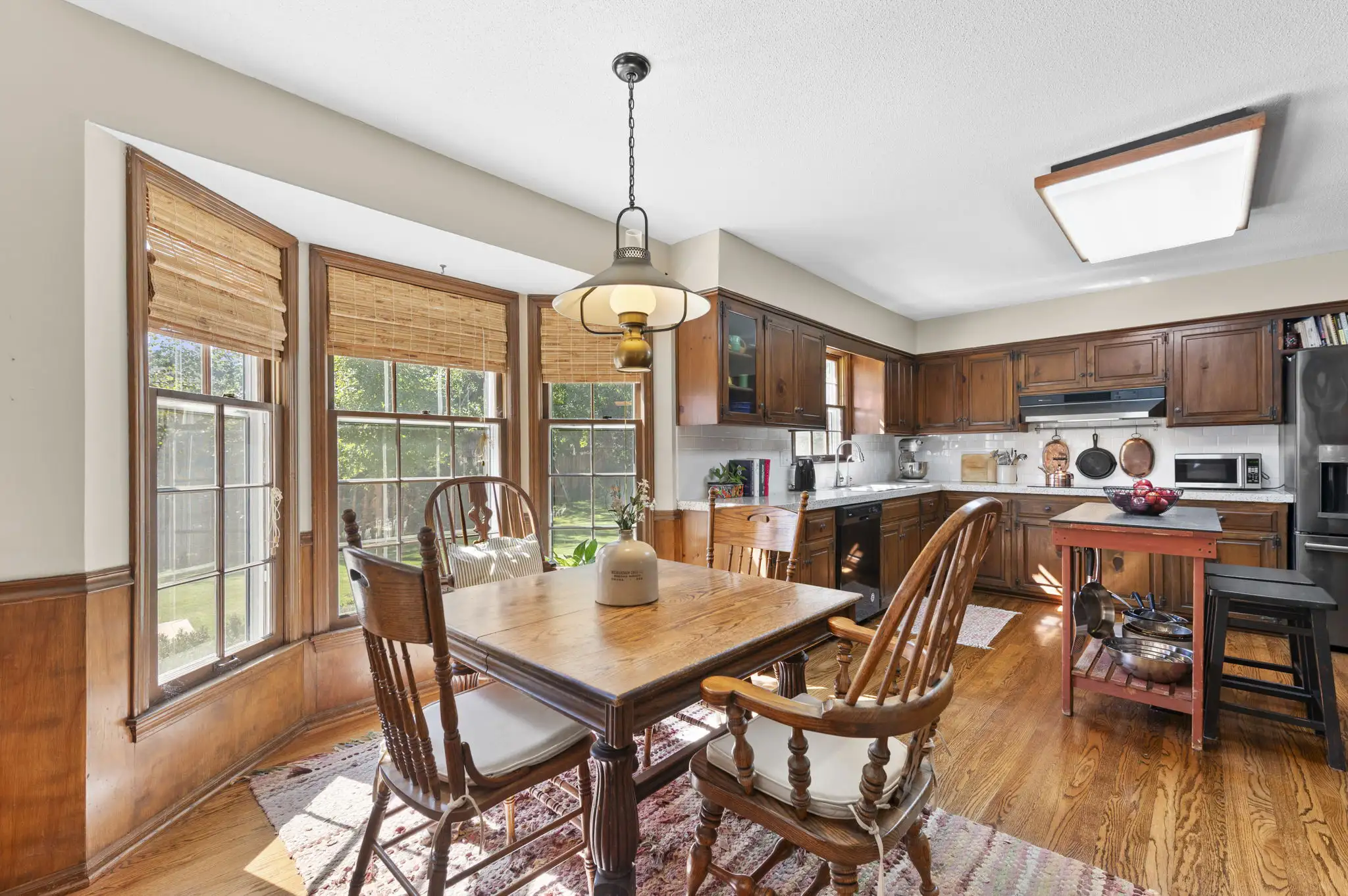 Bay-window breakfast nook with hardwood floors, open to the kitchen