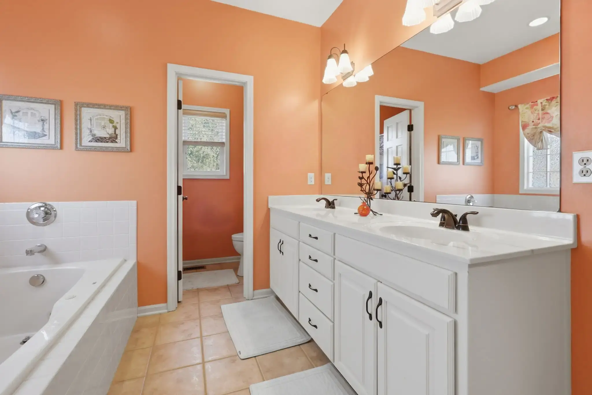 Primary bath with whirlpool tub, double vanity and private toilet room