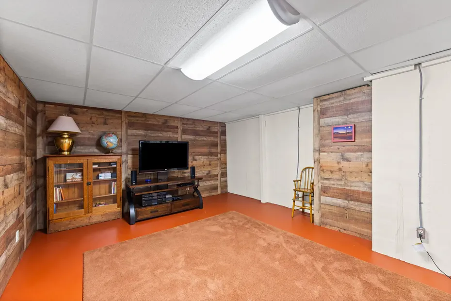 Lower level with wood plank accent walls and built-in storage closets