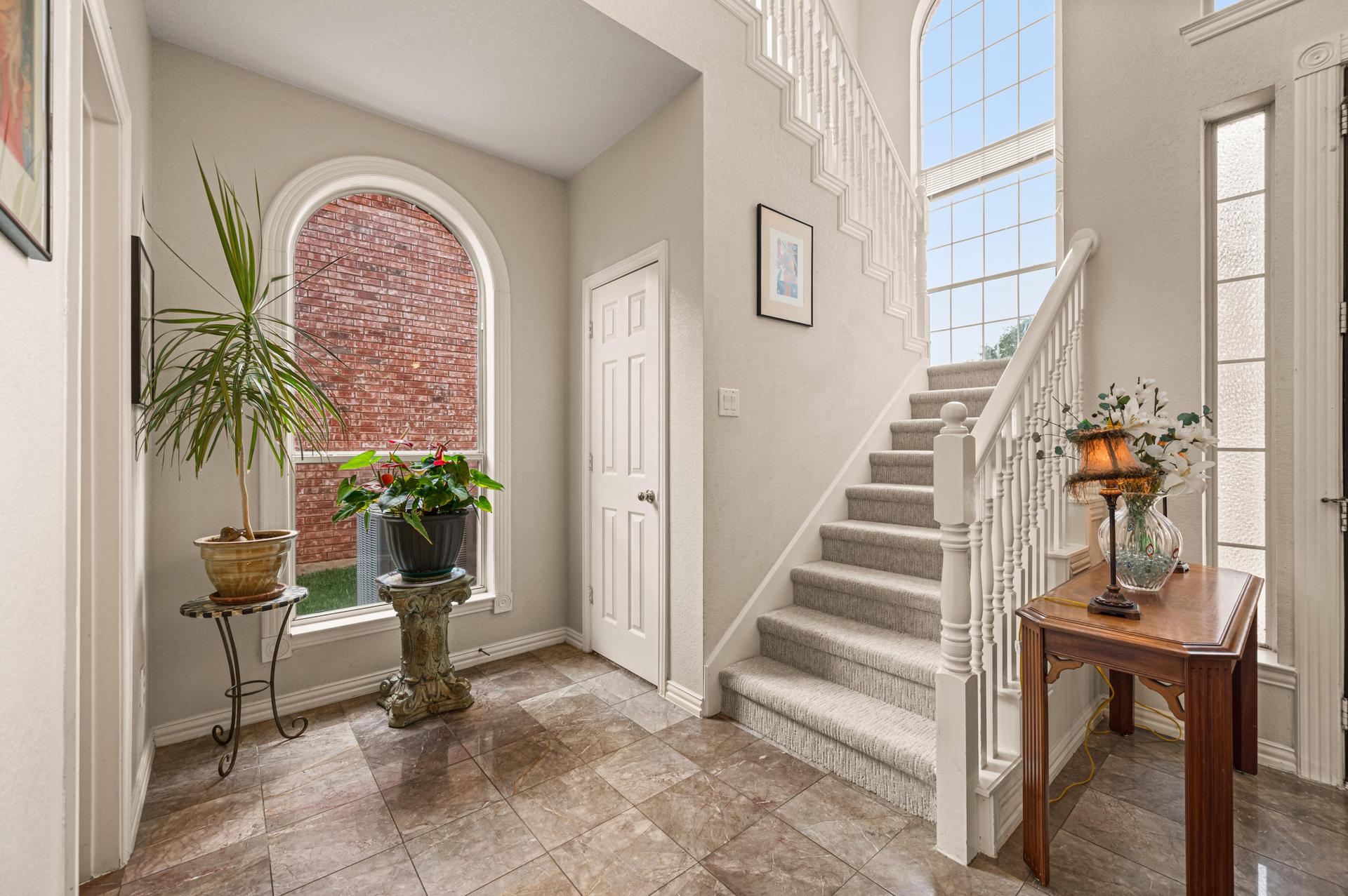 Two-story entry with staircase and arched front door at 7626 Lakecrest Circle