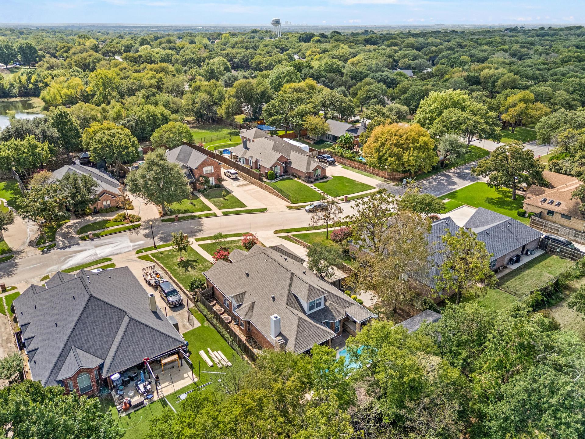 Aerial view of the surrounding neighborhood streets, sidewalks, and tree-lined properties
