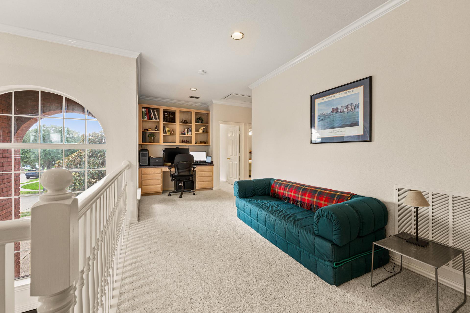 Upstairs living area with built-in shelving and seating area at 7626 Lakecrest Circle