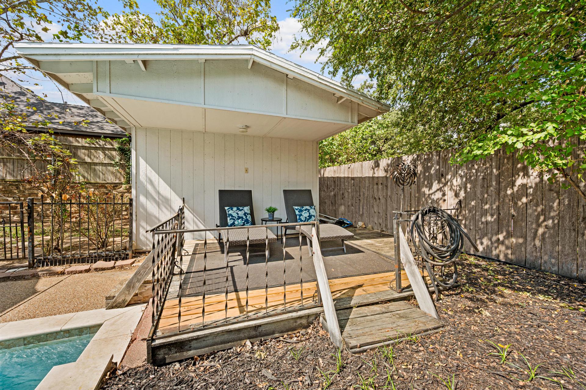 Detached structure with a partially covered raised deck and outdoor area beside the pool