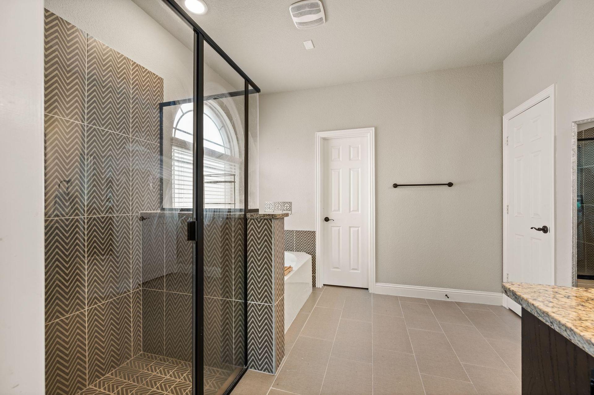Primary bathroom with dual vanities and garden tub at 4201 Rainwater Creek Way
