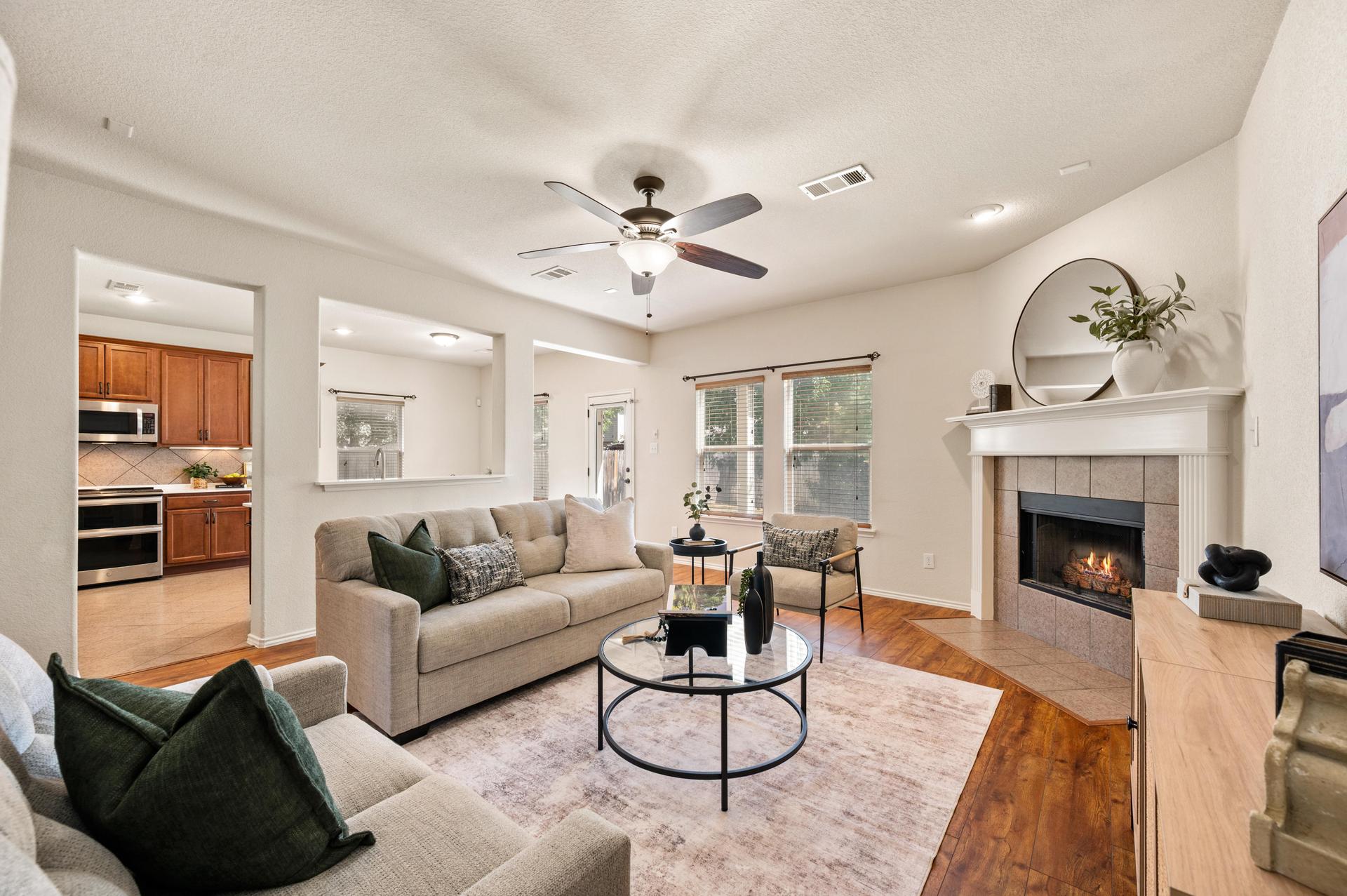 Open-concept living room at 625 Tradewind Drive in Fossil Hill Estates, North Fort Worth, featuring a fireplace and views toward the kitchen.