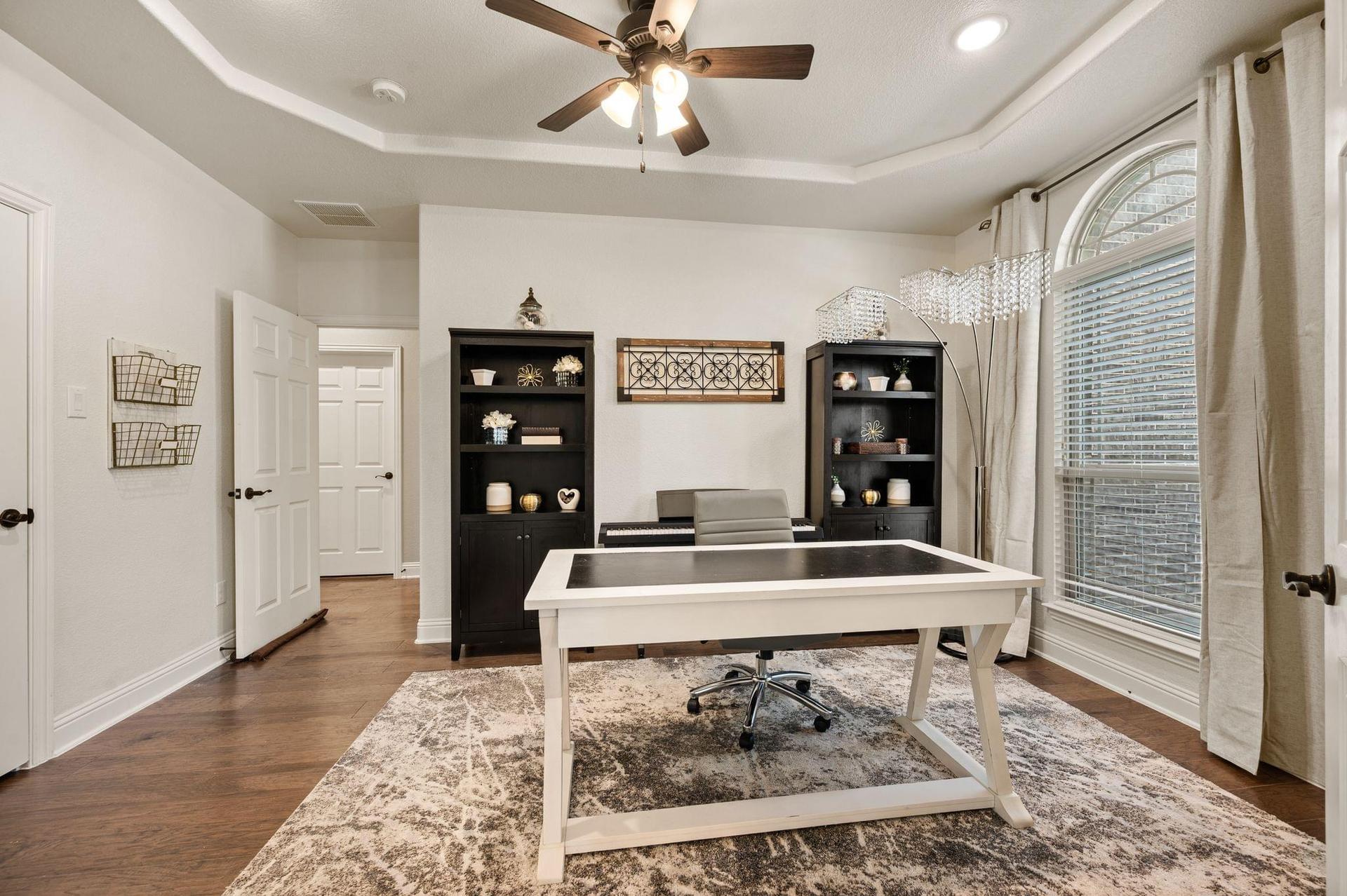 Dedicated home office with built-in shelving and large windows at 4201 Rainwater Creek Way in Celina, Texas