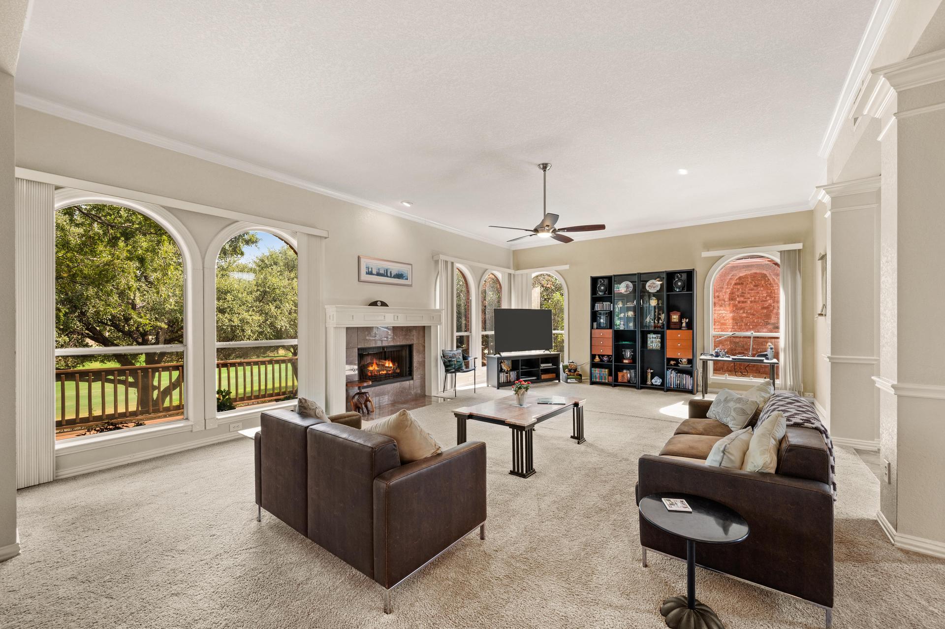 Spacious living room with fireplace, arched windows, and open-concept layout at 7626 Lakecrest Circle