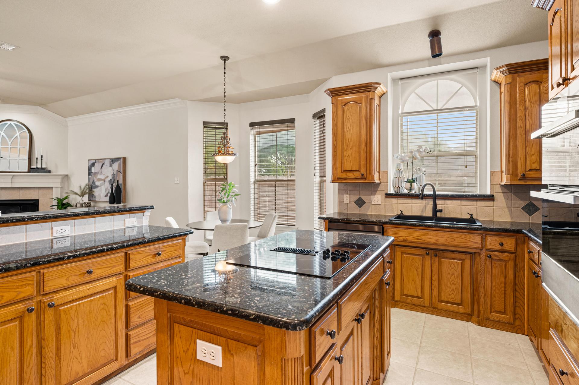 Kitchen at 7613 Woodhaven Drive, featuring granite countertops, center island, wood cabinetry, and spacious pantry
