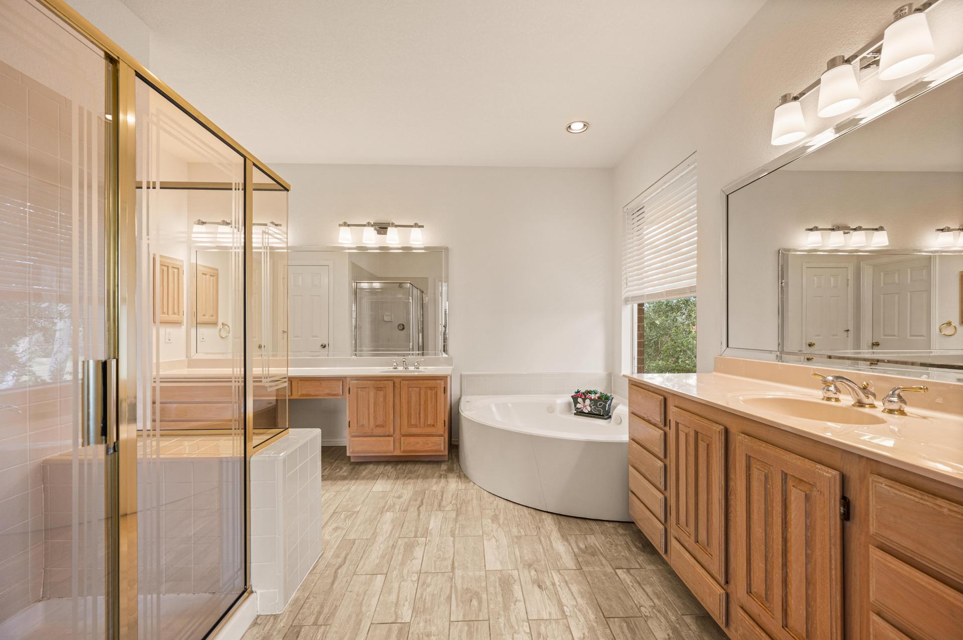 Primary ensuite bathroom with garden tub, double vanity, and separate shower at 7626 Lakecrest Circle