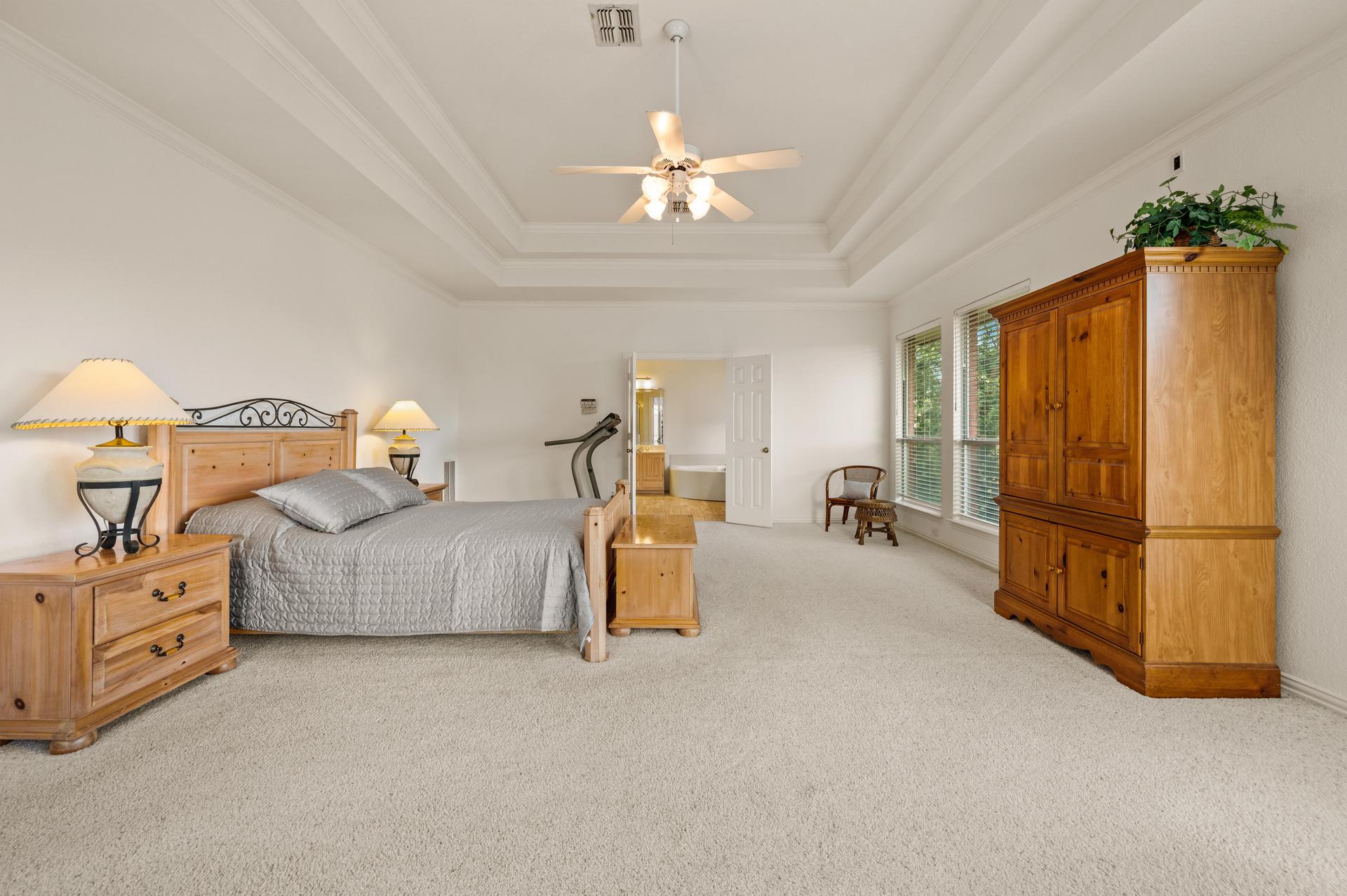 Spacious primary bedroom with sitting area and large windows at 7626 Lakecrest Circle