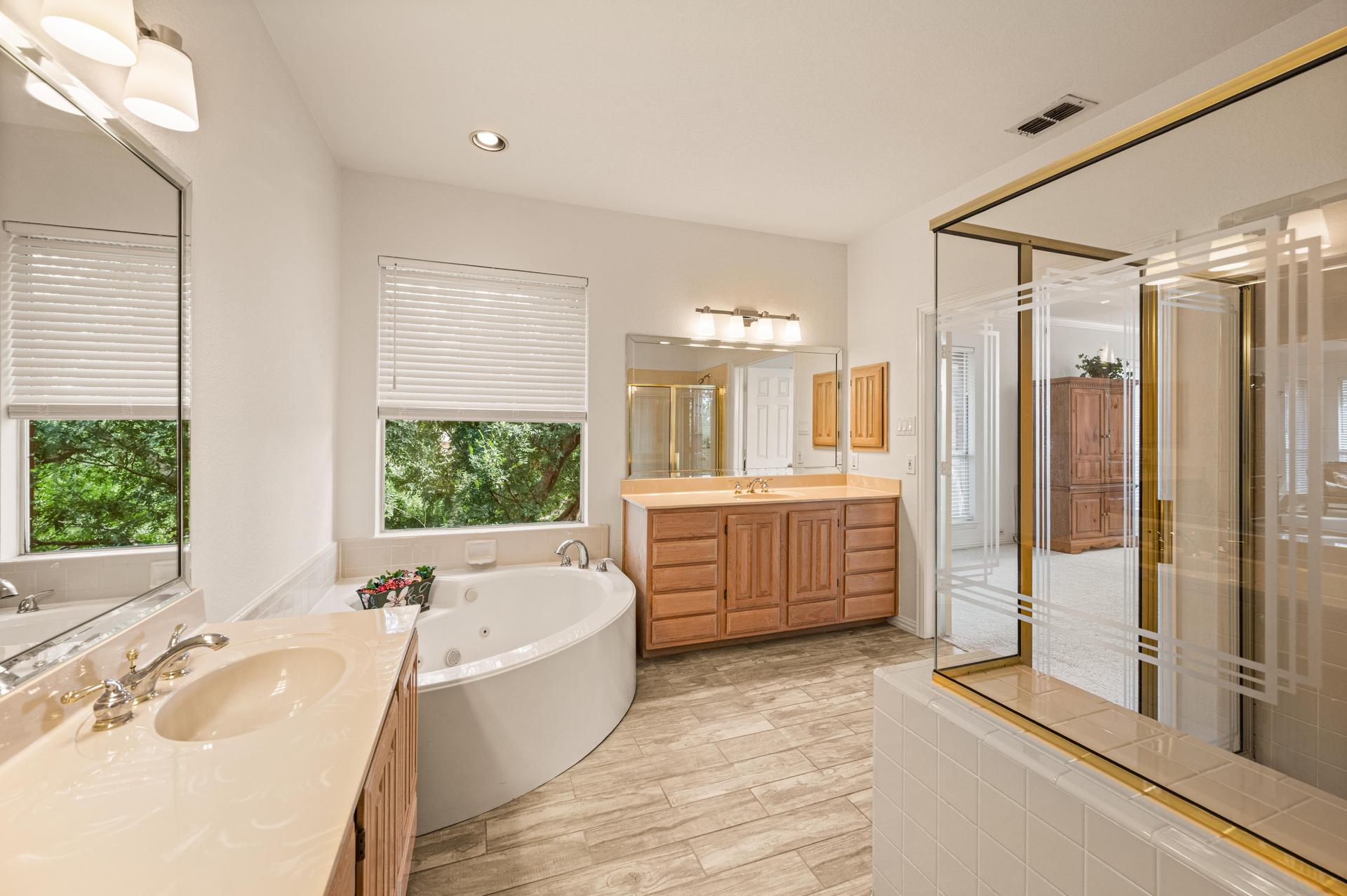 Primary ensuite bathroom with garden tub, double vanity, and separate shower at 7626 Lakecrest Circle