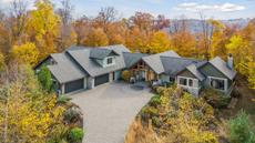 Aerial view of a luxury timber-frame home in Stillwater, Minnesota surrounded by peak fall color in the St. Croix River Valley
